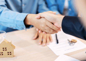 Property manager shaking hands with a rental property owner during a lease agreement meeting